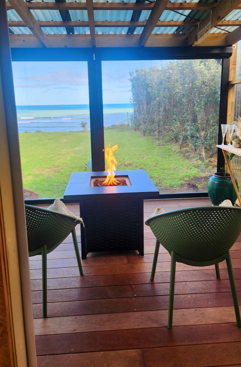 Fire table on the deck with the ocean beyond