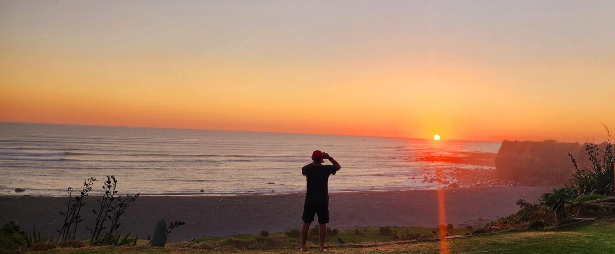 Sunset over the cove below Drift Inn, Opunake