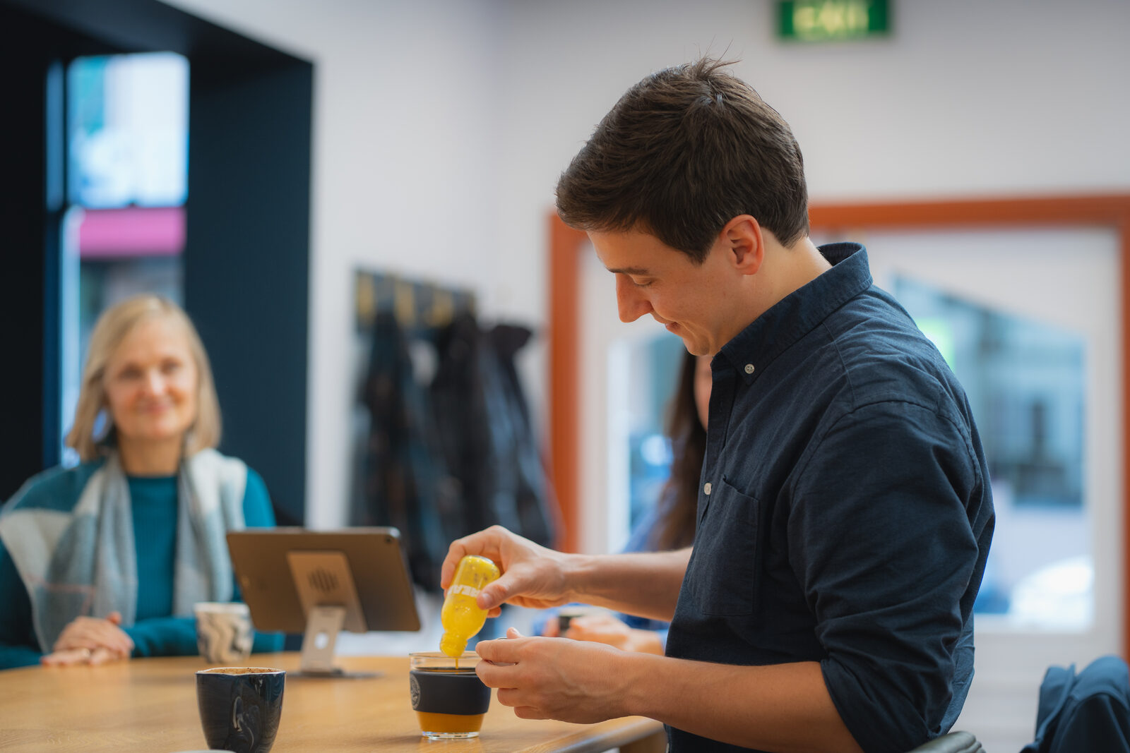 Xavier making coffee at the office table with a client